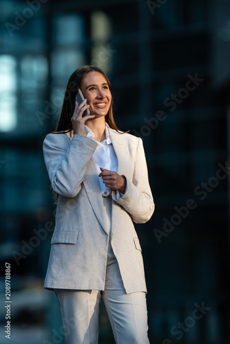 Businesswoman talking on smartphone outside office building