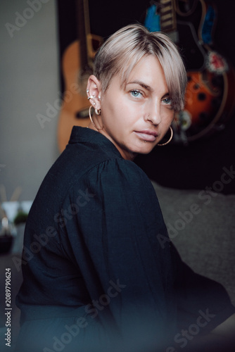 A beautiful model-looking girl with a short haircut, tanned skin, and light eyes