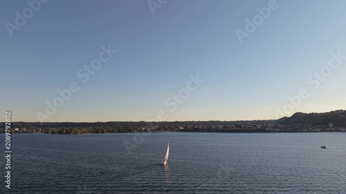 Aerial Sunset View of a Lone Sailboat on Calm Lake Water