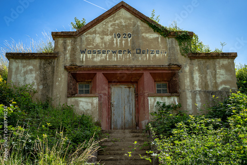 ehemalige Wasserwerk aus dem Jahr 1929, das sich still zwischen Weinreben und wildem Grün versteckt. Die Fassade trägt die Spuren der Zeit mit einer Würde, die man heute nur noch selten findet. Währen