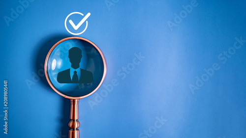 Magnifying glass focusing on businessman icon with check mark for recruitment concept
