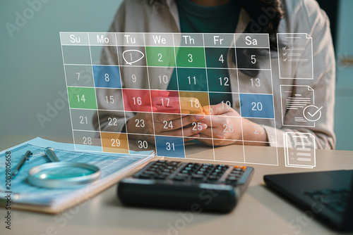 Business worker organizing schedule list via smartphone with virtual digital calendar backdrop