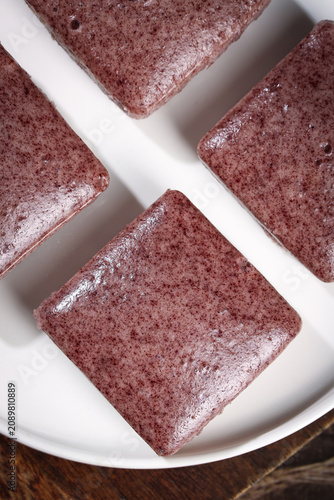 Bild auf Leinwand Handmade Black Rice Cake Squares on White Plate - Delicious Asian Breakfast Dess