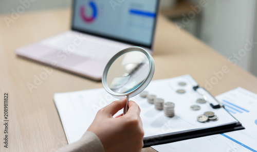 Foto Financial audit and accounting analysis with magnifying glass examining coins an