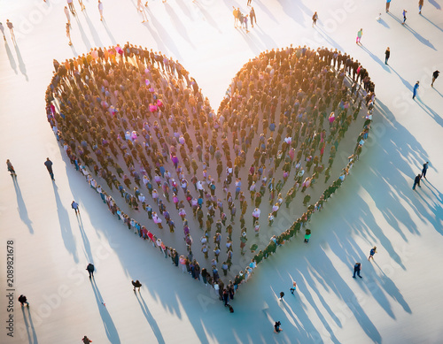 Large Group of People Forming a Heart Shape with Long Shadows