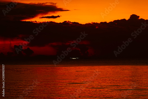 Foto Dramatic orange and red sunset sky reflecting on calm sea water