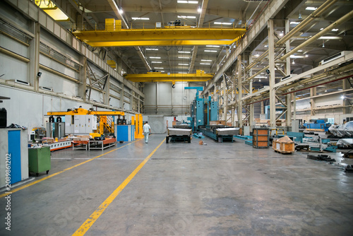 Bild auf Leinwand Industrial Factory Floor with Overhead Cranes and Heavy Machinery