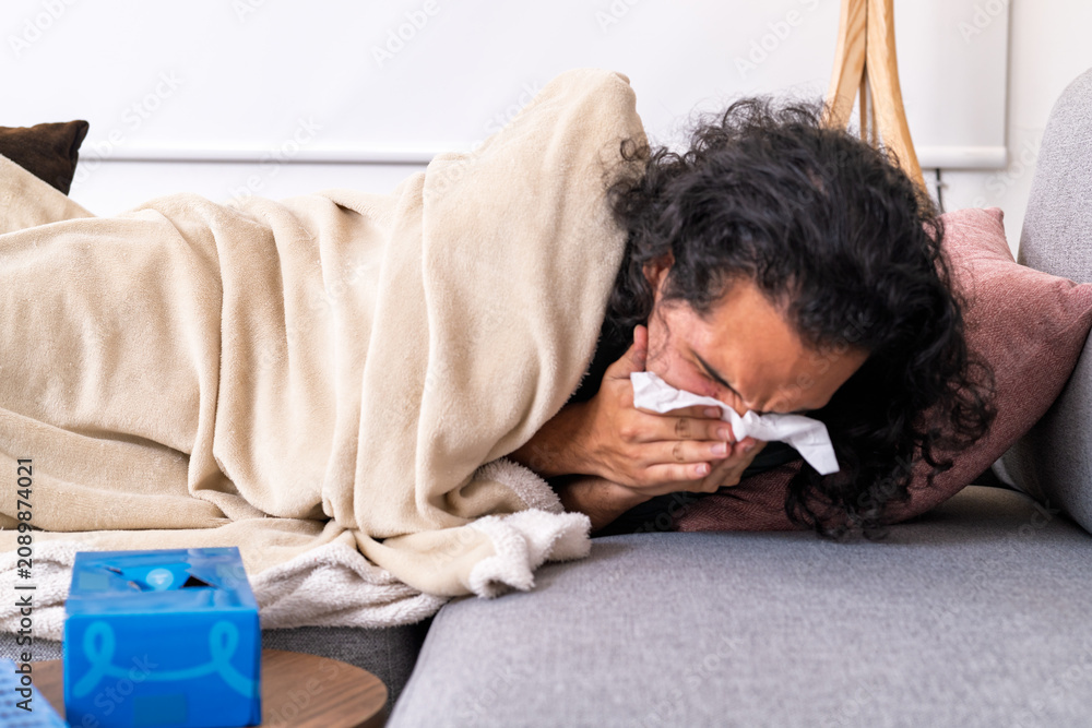Obraz premium Person blowing nose feeling sick at home
