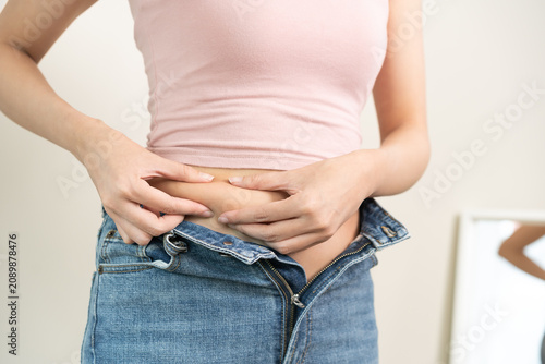 Foto Weight gain, overweight, high cholesterol and pressure, woman hand pinching exce