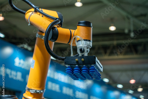 Canvas Print Industrial robotic arm with suction gripper in automated factory