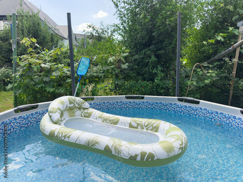 Obraz na płótnie Young woman relaxing on a floating air mattress in a backyard pool