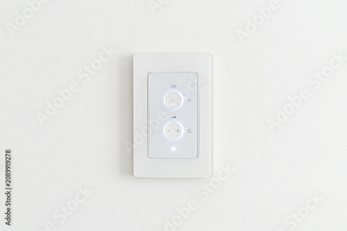Smart Home Control Panel: A modern white wall panel with two illuminated buttons and a dial, designed for intuitive control of smart home devices, embodying convenience and advanced technology.