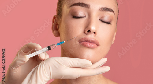 Cuadro en lienzo A woman receives a cosmetic procedure in a clinical environment, focusing on facial enhancement
