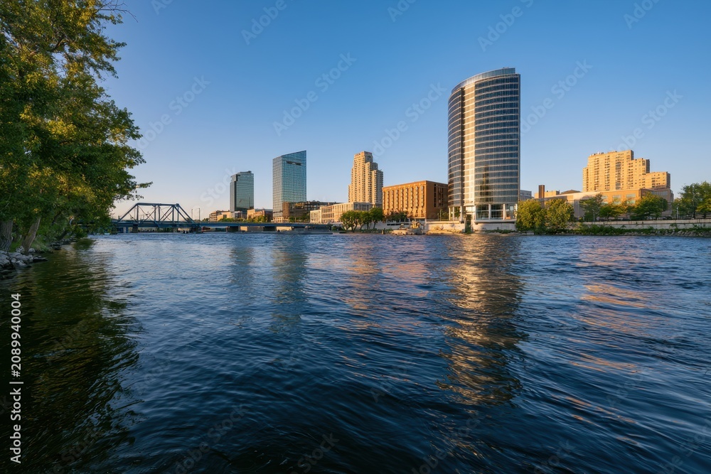 Obraz premium Riverfront panorama of Grand Rapids, Michigan, with modern glass towers reflected on the Grand River