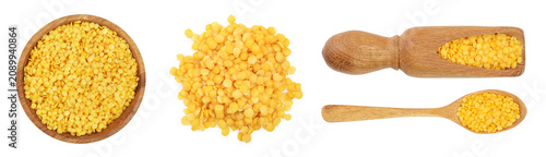 yellow lentil in wooden bowl isolated on white background. Top view