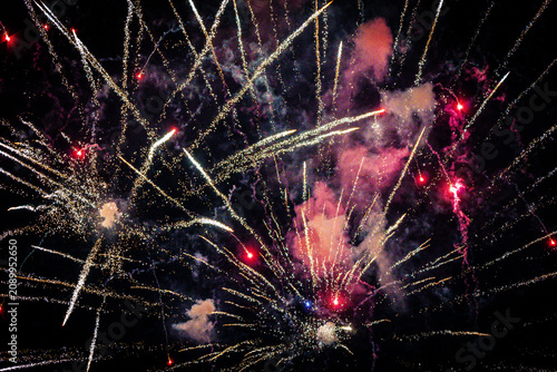 white and red fireworks exploding against dark night sky
