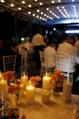 Принти на полотні A warm and inviting candlelit dinner party with blurred guests in the background