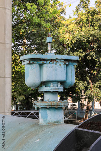 Blue industrial valves in outdoor setting in the city's water supply system.