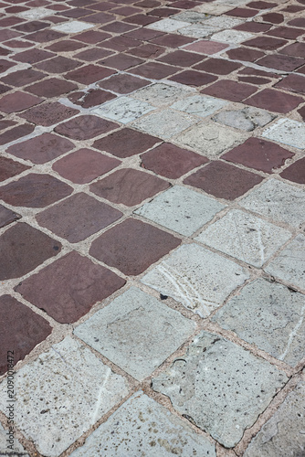 Old Pavement road. Background of bricks road. Stone cladding pavement. Brick surface background. Rough brick road. Cobblestone pavement background.
