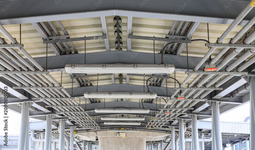 Fototapeta premium electrical steel pipeline, Electrical cable wire way on wall, cable routing between electrical distribution panel with equipment, industry construction concept background.