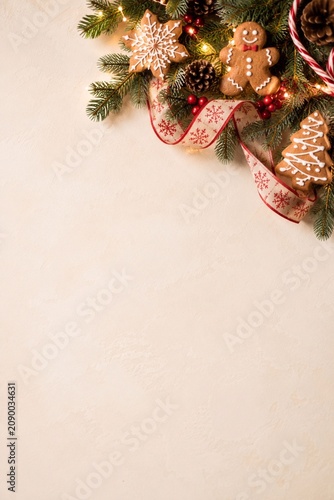 Festive Christmas Ornament Corner With Copy Space Christmas ornaments, gingerbread, evergreen branches, and warm decorations frame a beige background with empty space for holiday designs