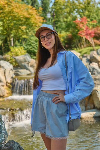 A girl walks through a Japanese garden in summer