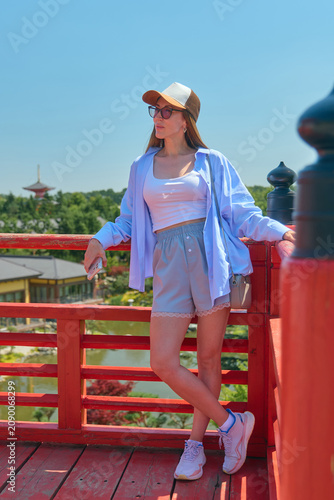 A girl walks through a Japanese garden in summer