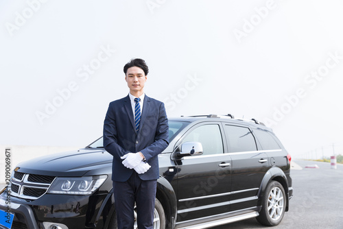 Photography Professional chauffeur standing beside black SUV for executive transportation se