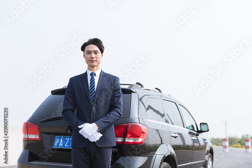 Photography Professional chauffeur standing by black SUV in Shanghai, China
