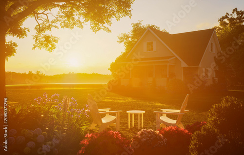Cozy cottage house backyard with patio chairs at warm golden sunset