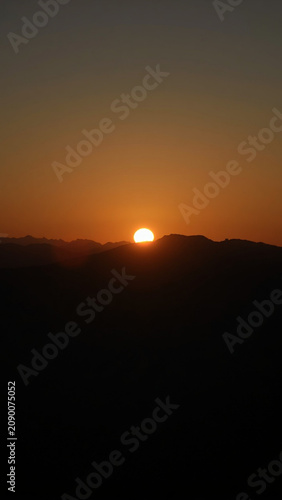 Sunrise Over Mountain Horizon with Golden Sky and Silhouetted Peaks