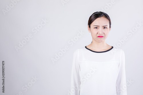 Bild auf Leinwand Young woman with displeased expression on plain background