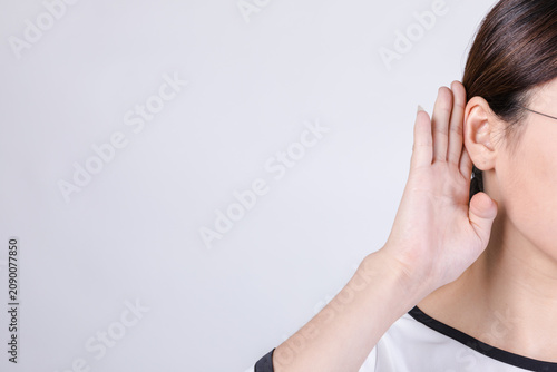 Canvas Print Close-Up Woman Listening with Hand to Ear on Plain Background