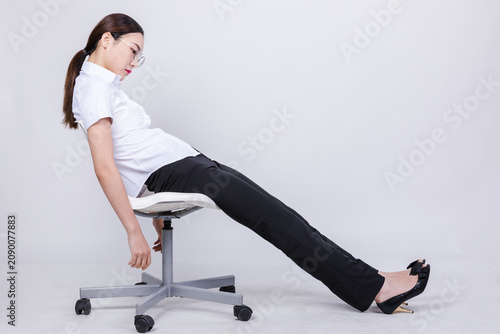 Quadro su tela Exhausted businesswoman slumping on office chair in studio