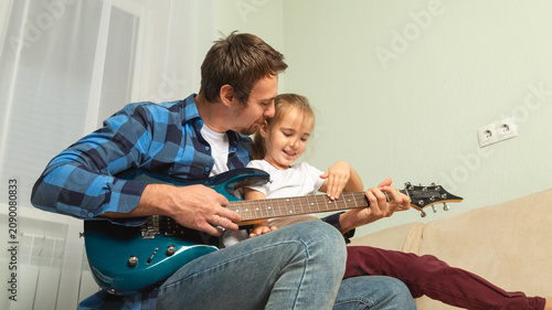 Father, girl and learning guitar in home, bonding and having fun together. Dad, child and playing instrument, teaching or education for music lesson, smile and enjoying quality time in house