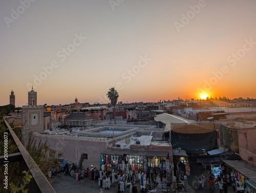 Foto The sunset paints Marrakesh rooftops and bustling market stalls near Jemaa El-Fna, Morocco