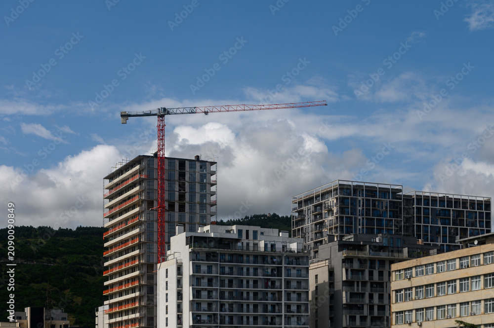 Fototapeta premium Construction Crane Above Residential High-Rise Buildings
