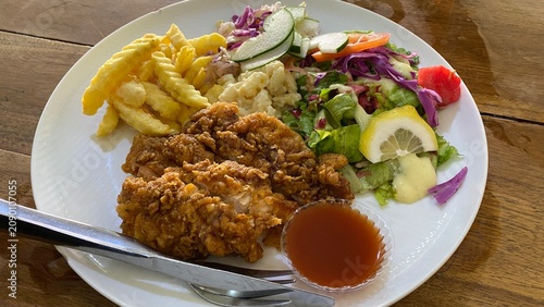 Crispy fried chicken cutlet served with golden french fries, fresh salad, and dipping sauce
