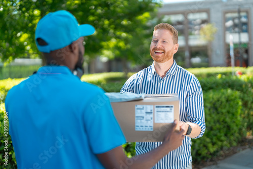 Canvastavla Happy customer receives a parcel from a courier during a successful last-mile delivery