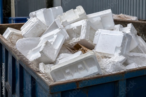 Styrofoam blocks piled and discarded in metal dumpster