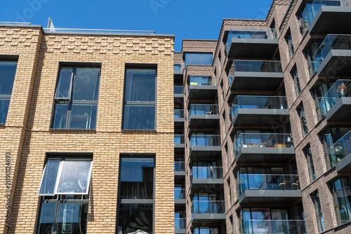 Modern Residential Buildings With Brick And Glass Facades Under Clear Blue Sky