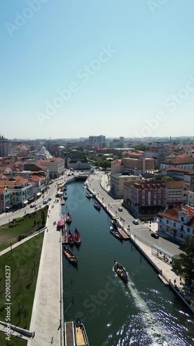 Drone panning shot revealing Aveiro city architecture, river and boats
