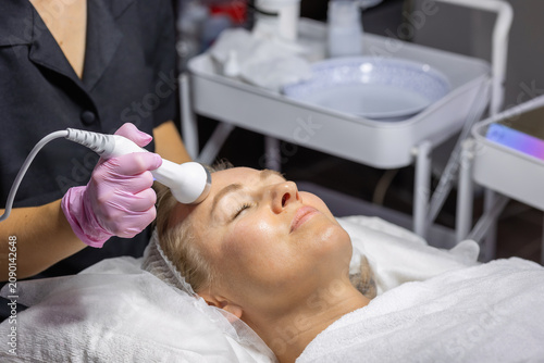 Foto Woman receiving a professional non-invasive facial treatment with a modern beauty device to improve skin tone, firmness and natural glow in a cosmetic clinic