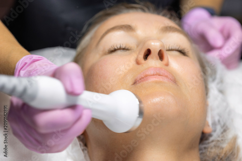 Foto Professional aesthetic treatment using a modern beauty device on the chin to improve skin firmness, facial contour and youthful appearance in a cosmetic clinic