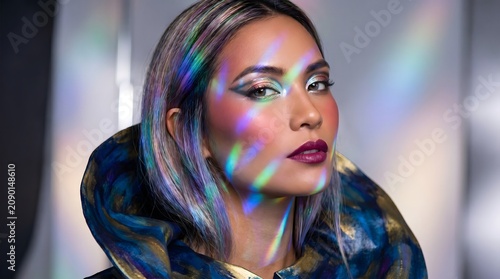 portrait of a striking woman with multi-color highlights and reflections across her face