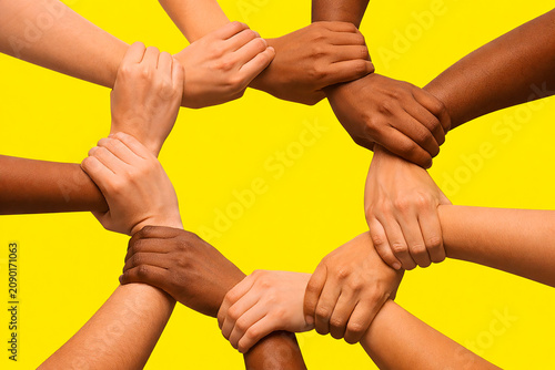 A symbolic illustration of diverse hands interlocking to form a circle of unity against a bright background. The design represents teamwork, solidarity, diversity, and empowerment, making it ideal for