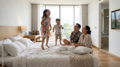Ultra Realistic Photography of Indonesian Family Relaxing in Modern Hotel Room During School Vacation Holiday