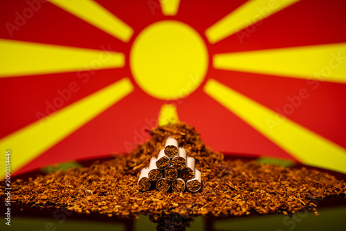 Obraz na płótnie Close up of cigarettes with loose tobacco and North Macedonia flag background