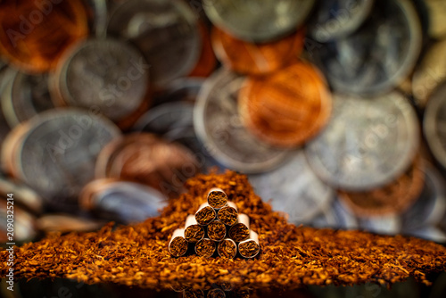 Fotografie Close up of cigarettes with loose tobacco and coins background.
