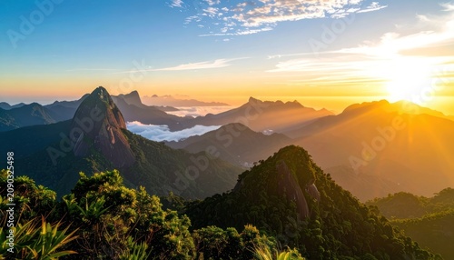 Sunrise illuminates lush green mountains and peaks emerging from clouds.